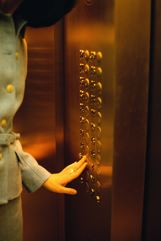 Businesswoman Pushing Elevator Button